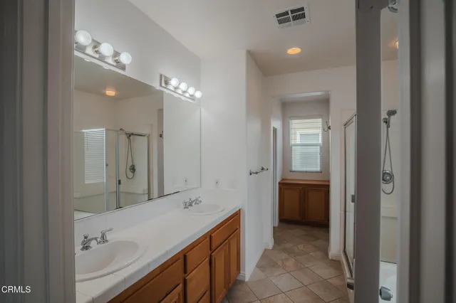 a bathroom with a sink vanity granite tub and a mirror