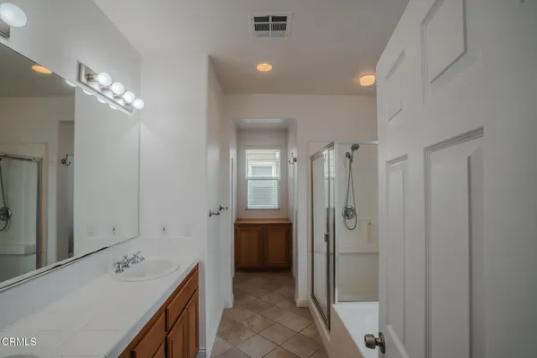 a bathroom with a tub sink a shower and a mirror