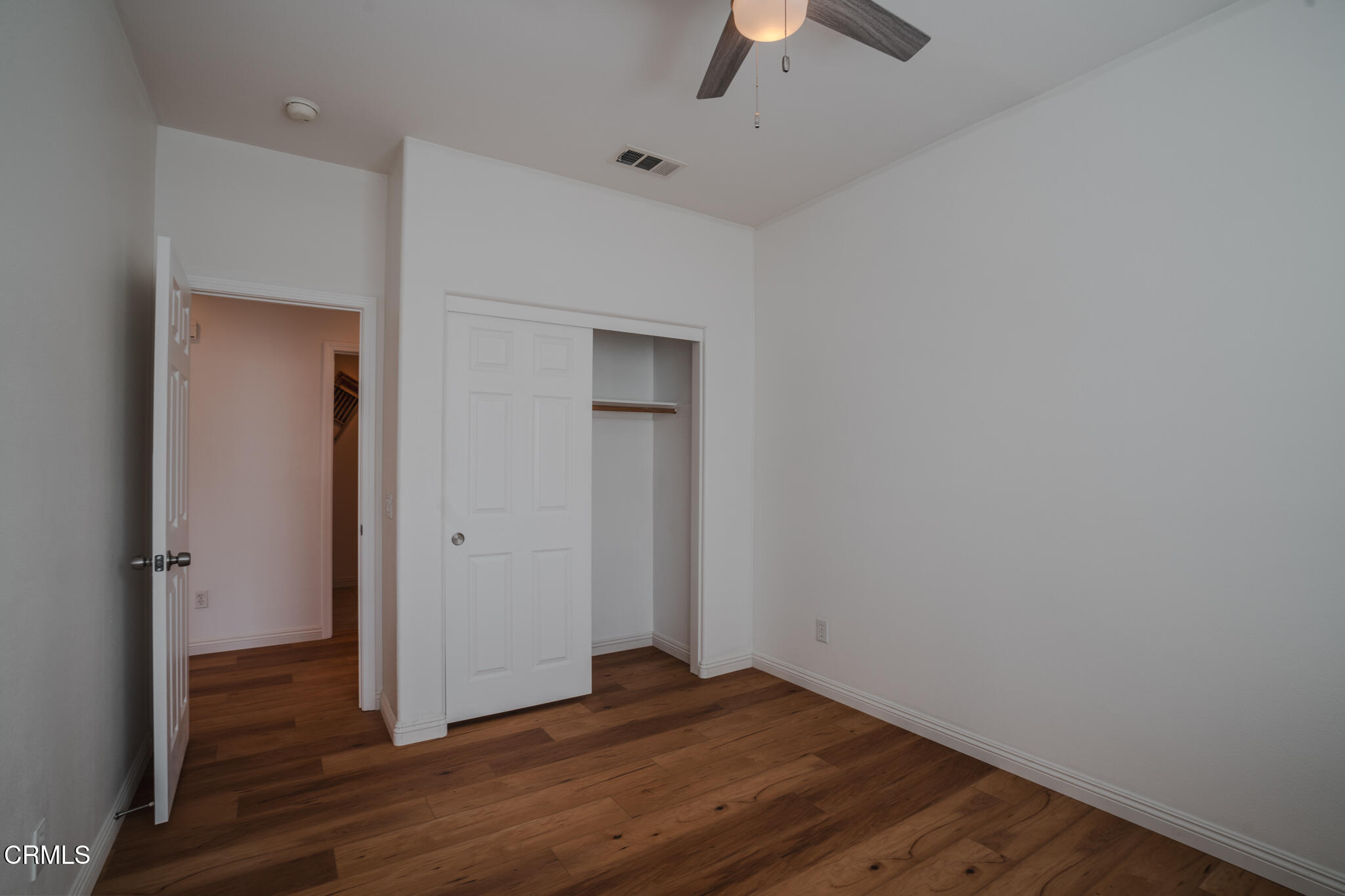 525 Shell Harbor Lane Port Hueneme, CA 93041 - Photo 38 of 47 an empty room with wooden floor and a ceiling fan