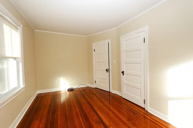 a view of a room with wooden floor and window
