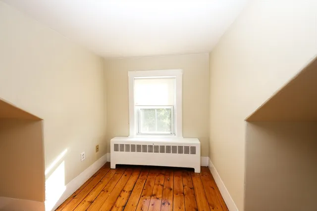 a view of a room with wooden floor and a window