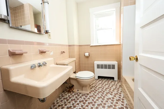 a bathroom with a sink a toilet and a mirror