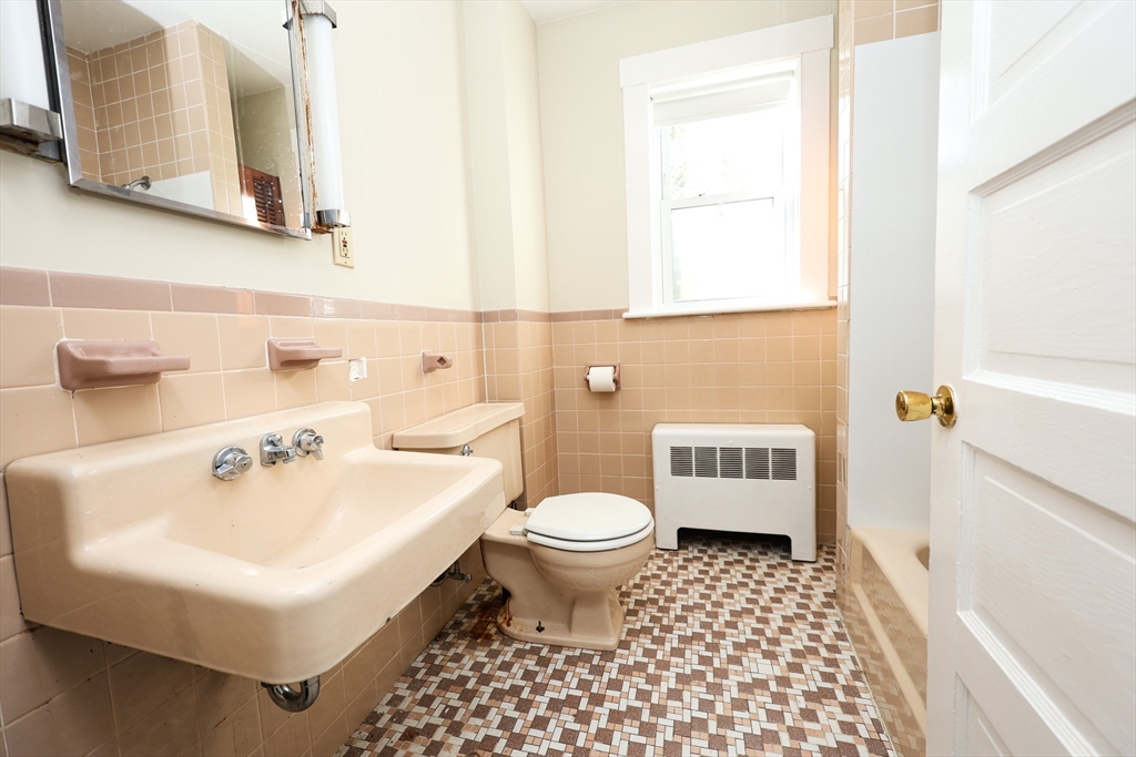 354 Pond Street, Unit 354 Braintree, MA 02184 - Photo 26 of 30 a bathroom with a sink a toilet and a mirror