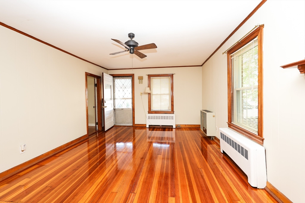 354 Pond Street, Unit 354 Braintree, MA 02184 - Photo 8 of 30 a view of an empty room with wooden floor and a window