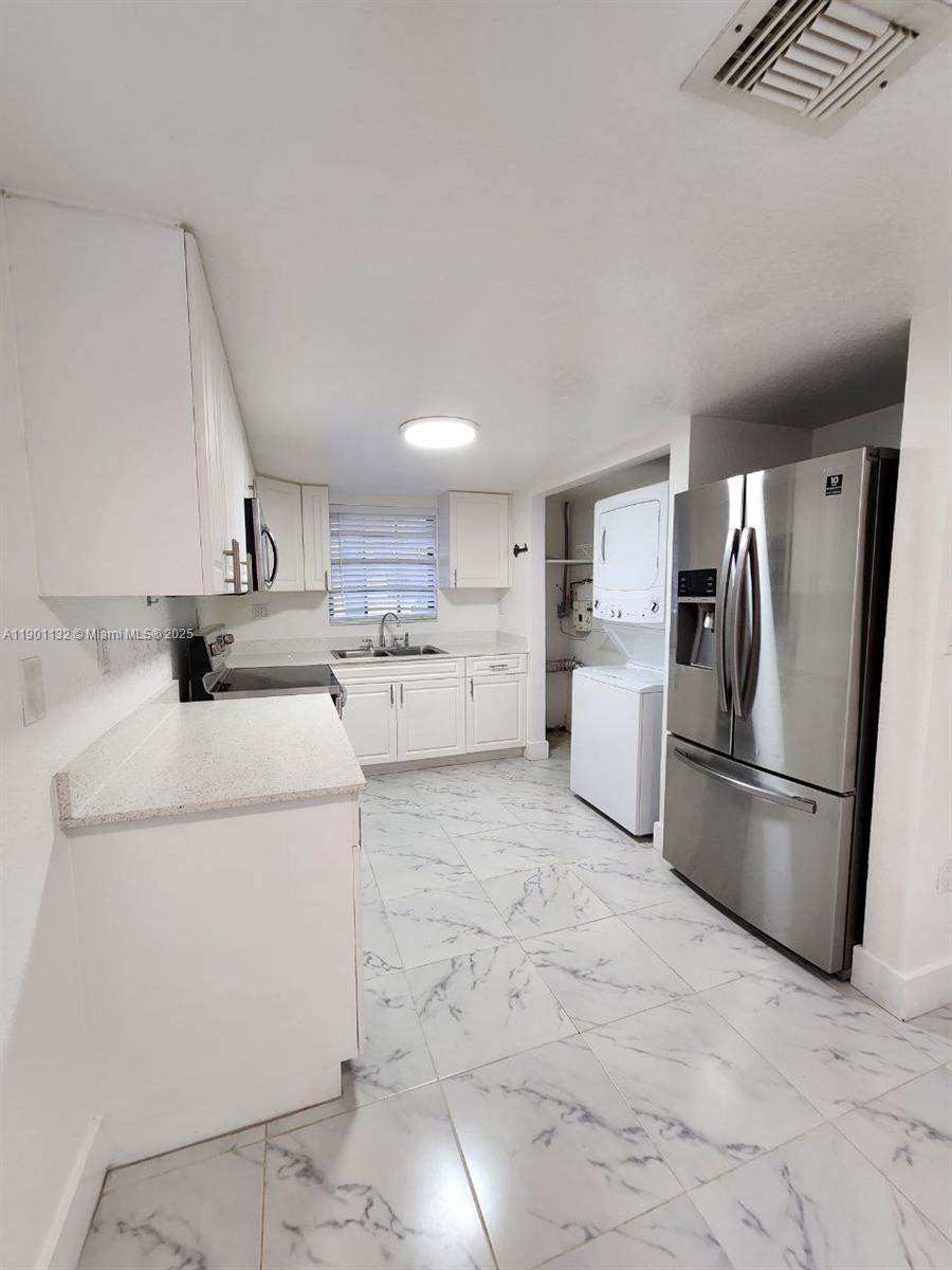 5100 West 12th Lane, Unit E7 Hialeah, FL 33012 - Photo 12 of 35 a kitchen with a refrigerator sink stove and microwave