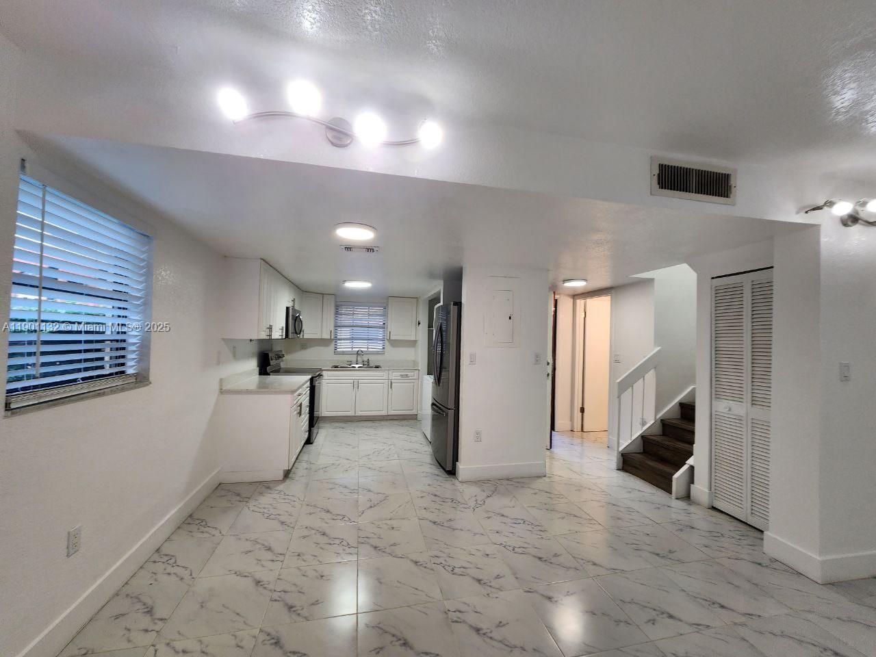 5100 West 12th Lane, Unit E7 Hialeah, FL 33012 - Photo 13 of 35 a view of a living room and a kitchen