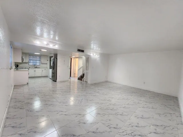a view of a kitchen with furniture and a refrigerator