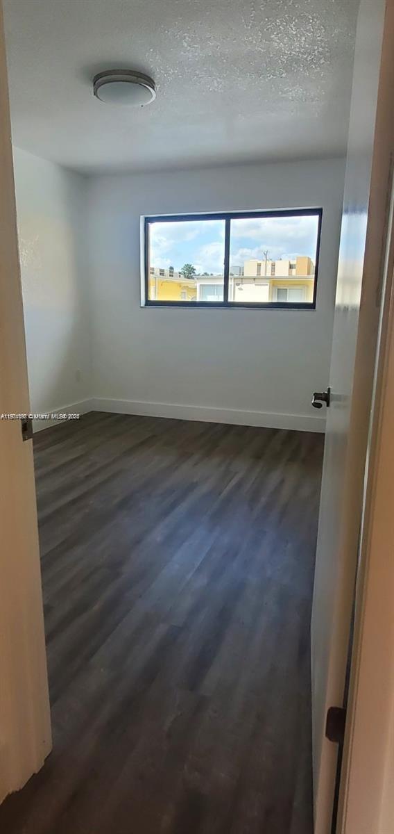 5100 West 12th Lane, Unit E7 Hialeah, FL 33012 - Photo 24 of 35 an empty room with wooden floor and windows