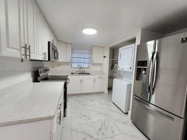 a view of a kitchen with a sink and a refrigerator