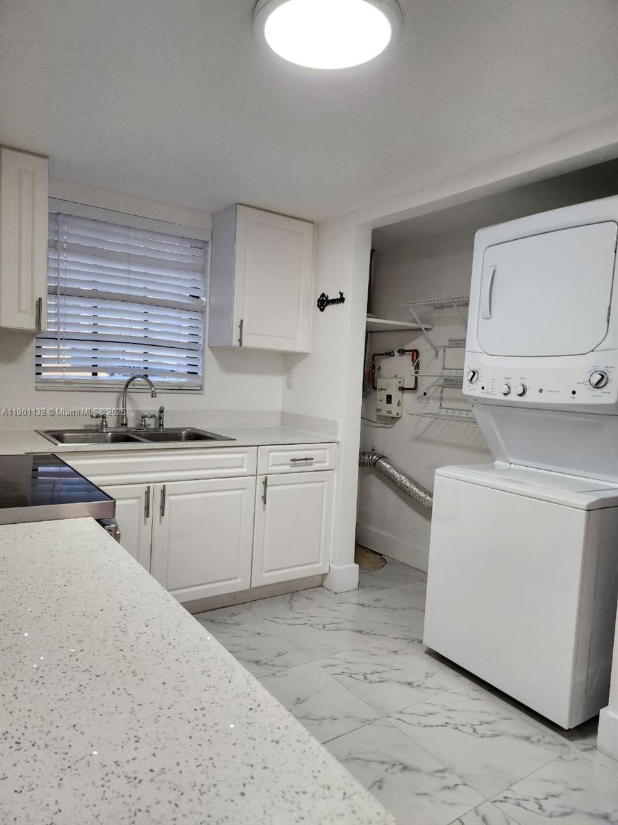 5100 West 12th Lane, Unit E7 Hialeah, FL 33012 - Photo 10 of 35 a kitchen filled with white cabinets and white appliances