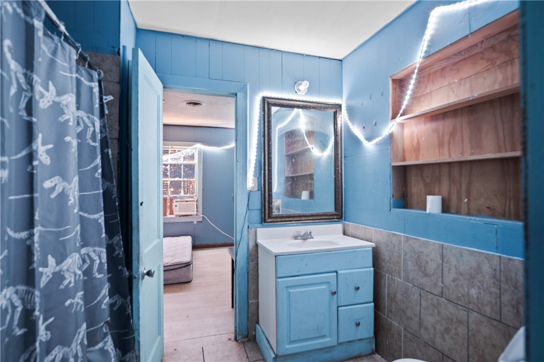 128 Northwest 6th Street Premont, TX 78375 - Photo 12 of 15 a bathroom with a sink a mirror and a shower