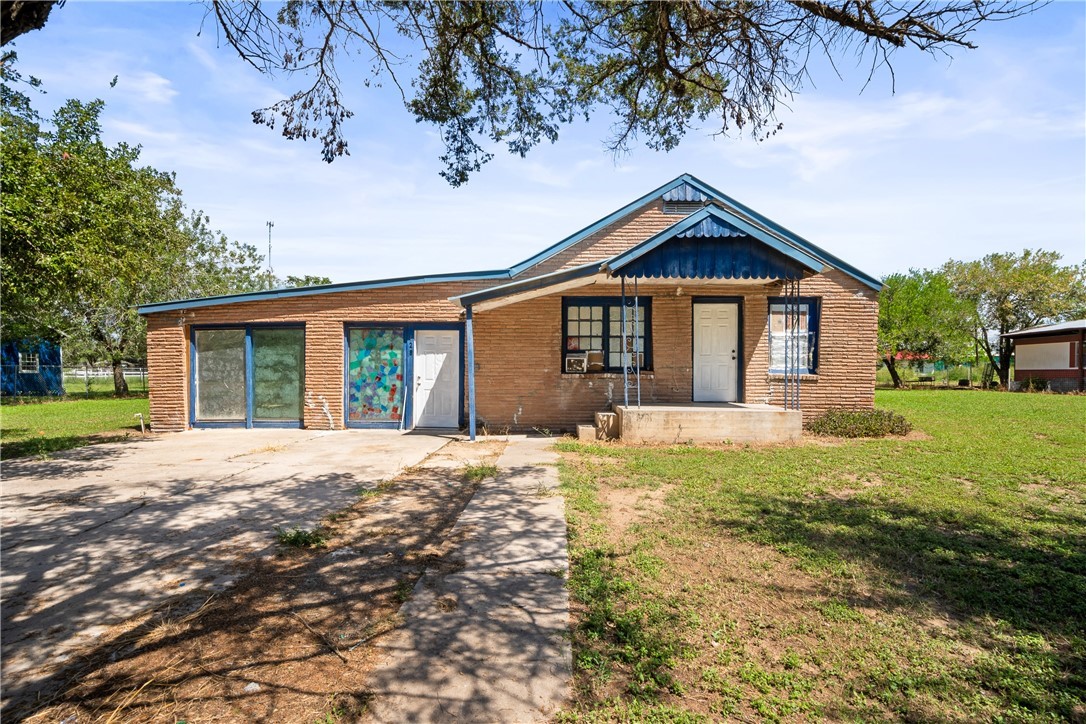 128 Northwest 6th Street Premont, TX 78375 - Photo 2 of 15 a front view of a house with a yard and garage