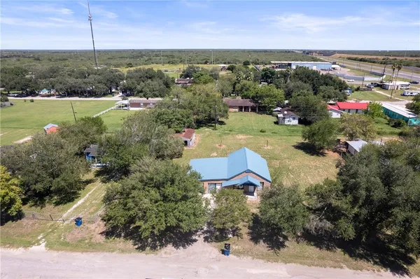 an aerial view of a houses with a yard and lake view
