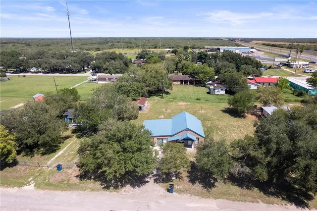 an aerial view of a houses with a yard and lake view