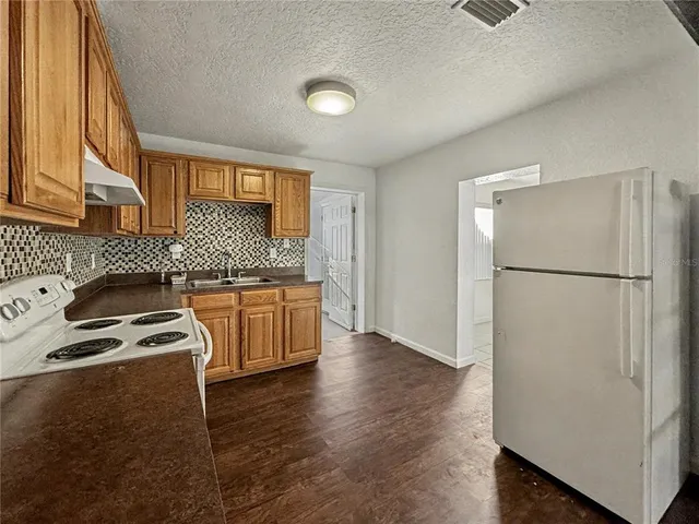a kitchen with a refrigerator sink and cabinets