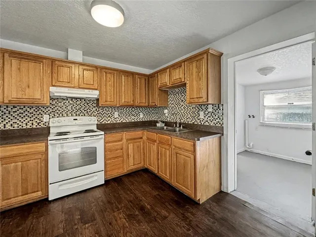 a kitchen with granite countertop white cabinets and white appliances