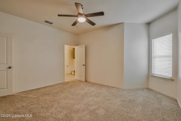 an empty room with a window and a ceiling fan