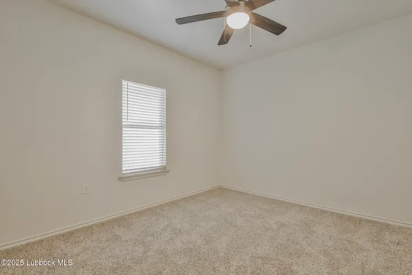 an empty room with chandelier fan