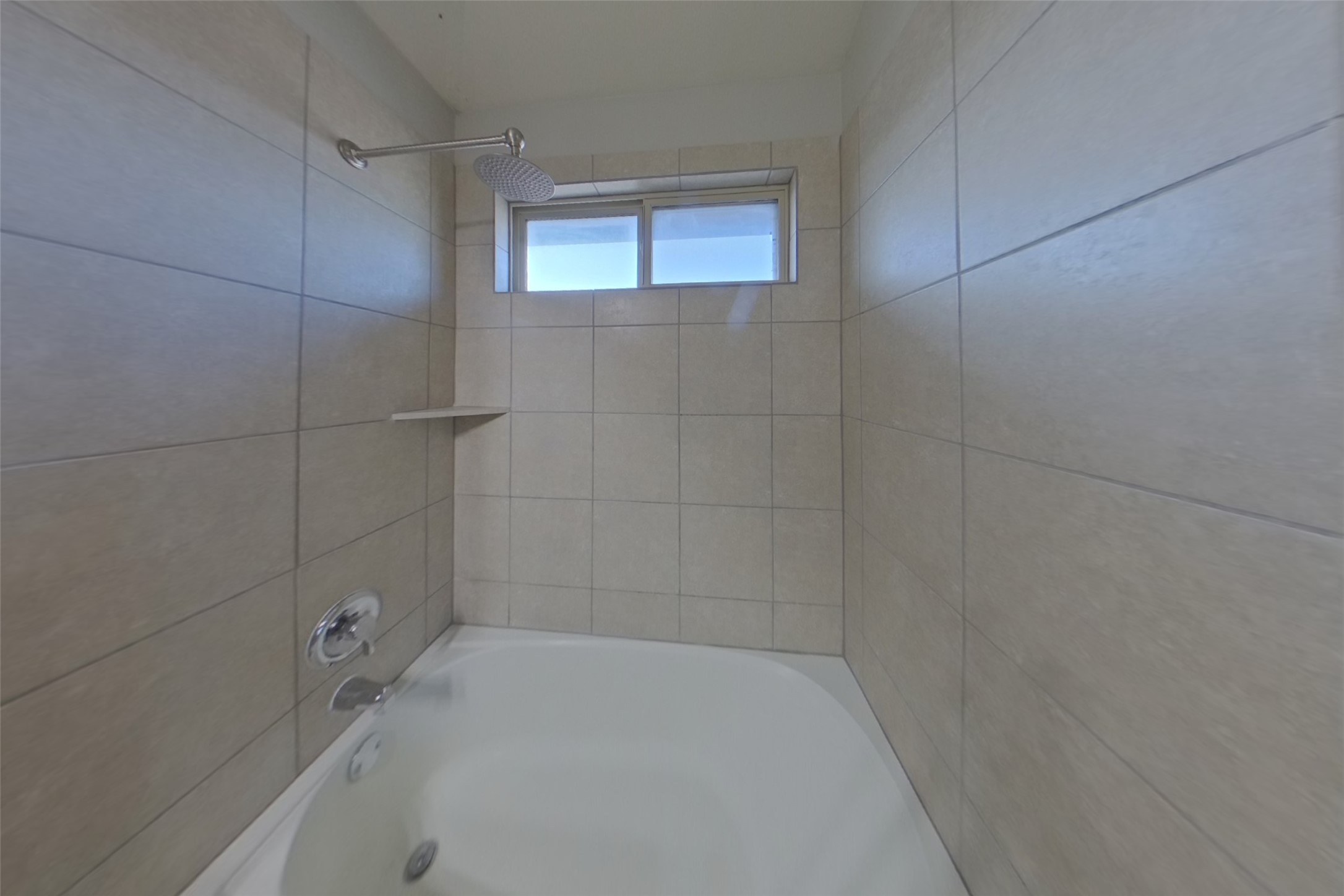 240 Dragon Ridge Road Buda, TX 78610 - Photo 9 of 20 Floor-to-ceiling tiles enclose a deep soaking tub positioned beneath a high window.