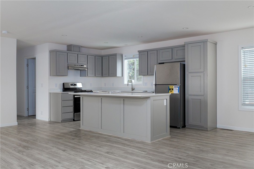 1255 Orcutt Road, Unit A11 San Luis Obispo, CA 93401 - Photo 7 of 22 a kitchen with kitchen island granite countertop a refrigerator and a stove top oven