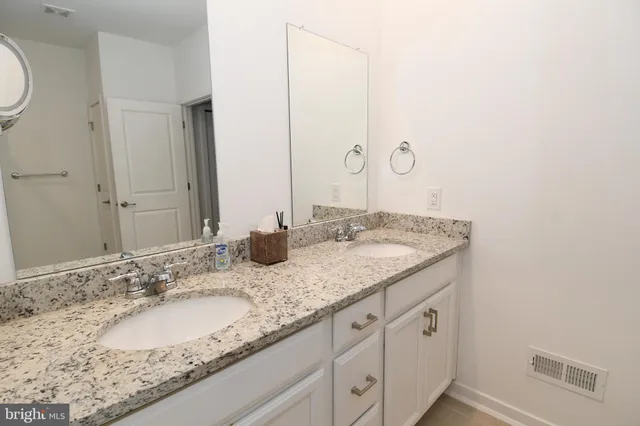 a bathroom with a granite countertop sink and a mirror