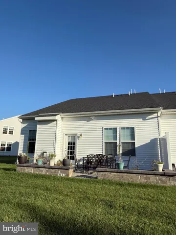 a front view of a house with a yard and outdoor seating