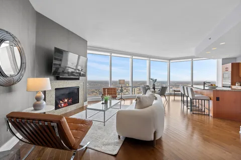 a living room with furniture a fireplace and a large window