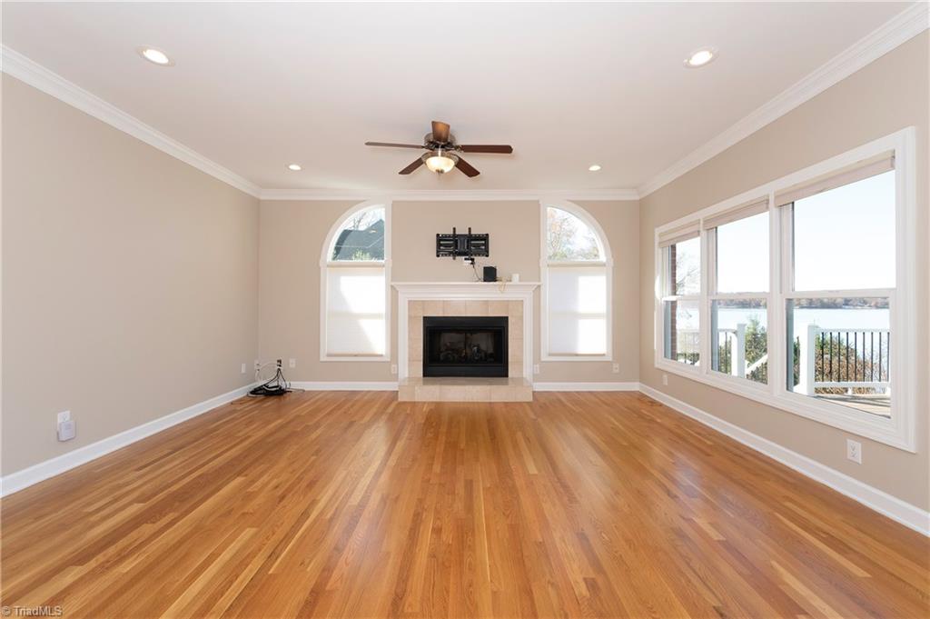 1851 Waterford Pointe Road Lexington, NC 27292 - Photo 13 of 49 Great room has gorgeous hardwood floors, ceiling fan, FP with gas logs and a wall of windows for a lake view