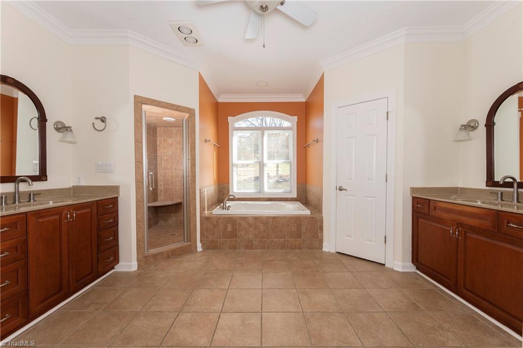 1851 Waterford Pointe Road Lexington, NC 27292 - Photo 29 of 49 Primary bedroom with ensuite bath with a jetted tub, tiled shower and separate sinks one with a makeup vanity
