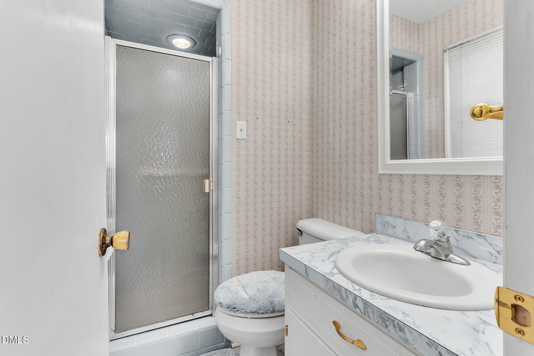 1828 Fletchers Chapel Road Durham, NC 27703 - Photo 16 of 36 a bathroom with a sink a toilet and shower