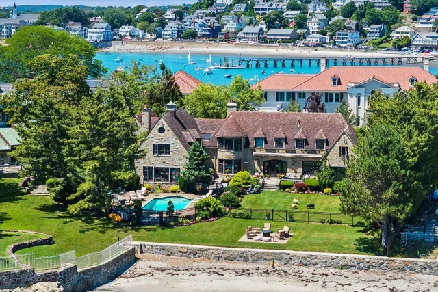 an aerial view of a house with a garden and lake view
