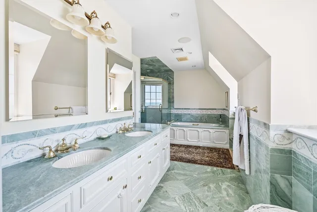 a bathroom with a granite countertop sink a mirror and shower