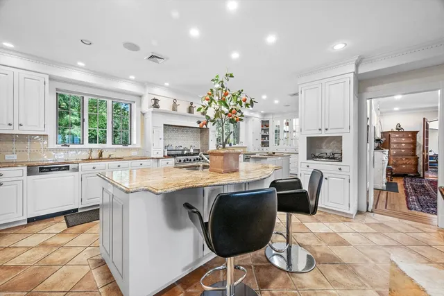 a kitchen with kitchen island granite countertop a sink and stove