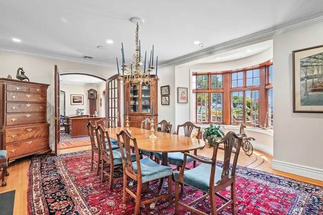 a dining room with furniture a chandelier and wooden floor