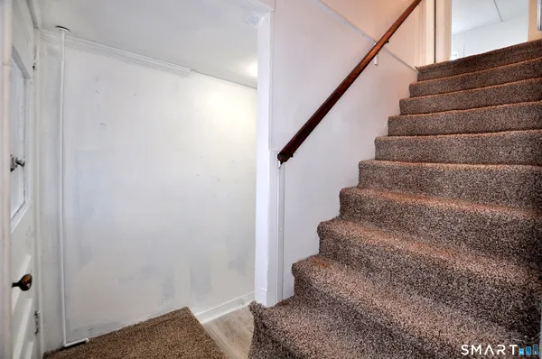 a view of a hallway with wooden floor and staircase
