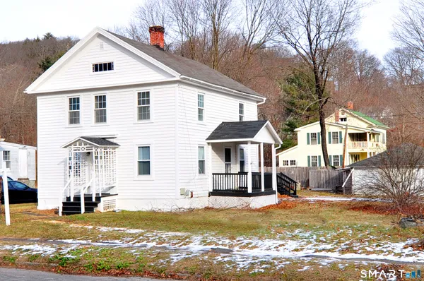 a view of a house with wooden deck and furniture