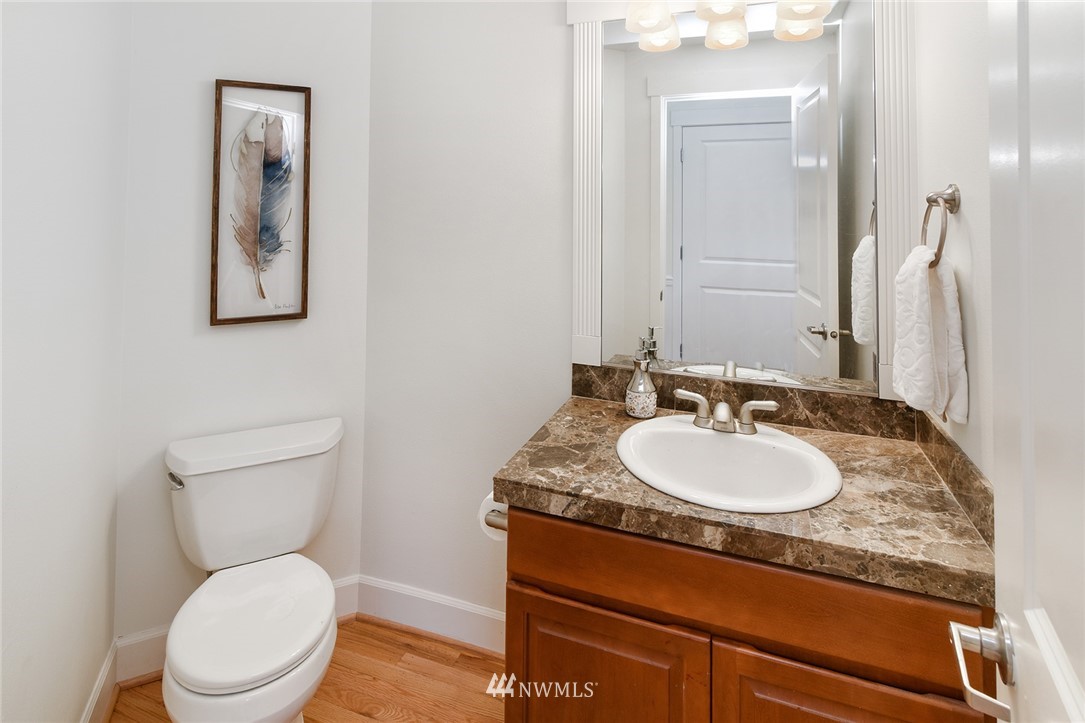 22548 5th Place West Bothell, WA 98021 - Photo 18 of 38 a bathroom with a granite countertop toilet a sink and mirror