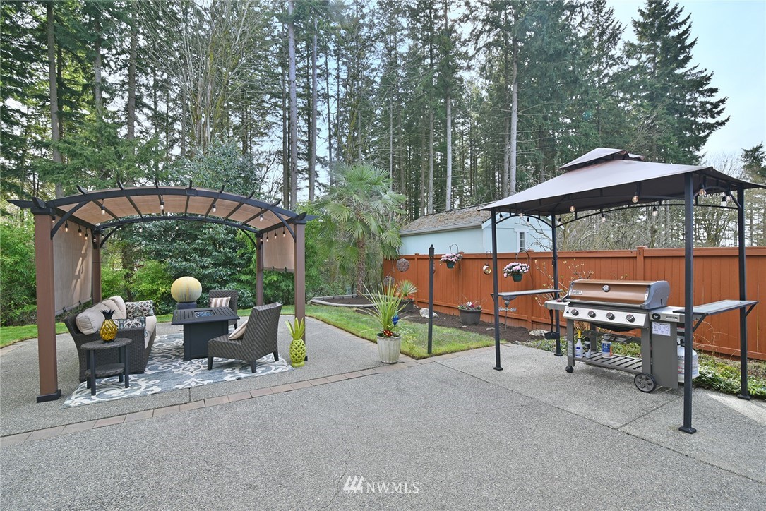 22548 5th Place West Bothell, WA 98021 - Photo 6 of 38 a view of a patio with table and chairs under an umbrella with a small yard