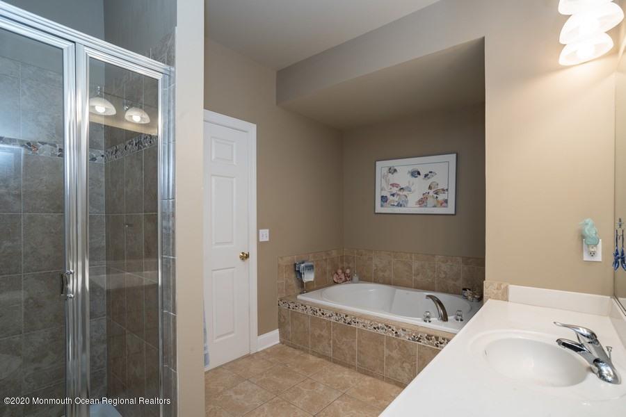 804 Abby Road Middletown, NJ 07748 - Photo 14 of 19 a bathroom with a granite countertop tub sink and shower