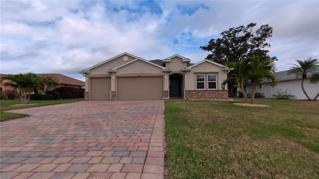 25326 Tether Lane Punta Gorda, FL 33983 - Photo 2 of 19 a front view of a house with a garden and yard