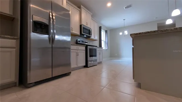 a kitchen with stainless steel appliances a refrigerator and a counter top space