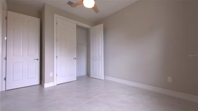 a view of an empty room and a ceiling fan