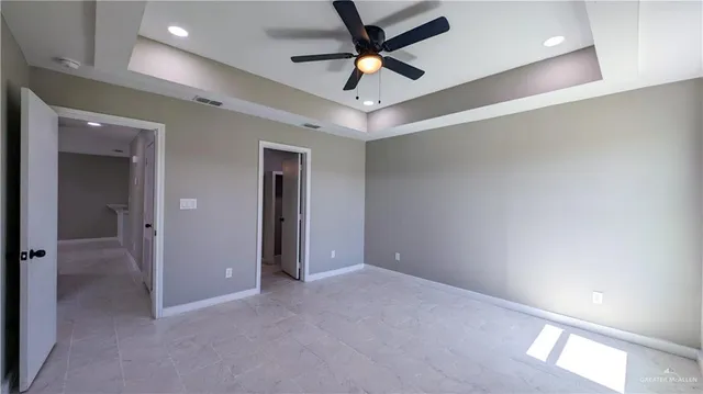 en empty room with windows and ceiling fan