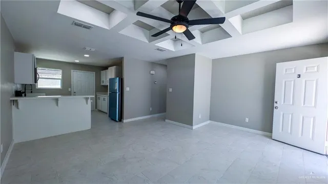 a view of a kitchen with a sink and a refrigerator