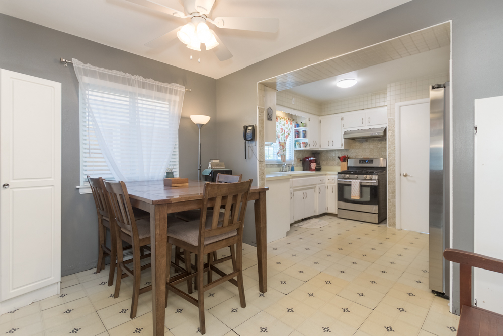 6204 35th Street Berwyn, IL 60402 - Photo 10 of 30 a kitchen with kitchen island a dining table chairs and white cabinets