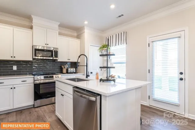 a kitchen with stainless steel appliances granite countertop a sink stove and cabinets