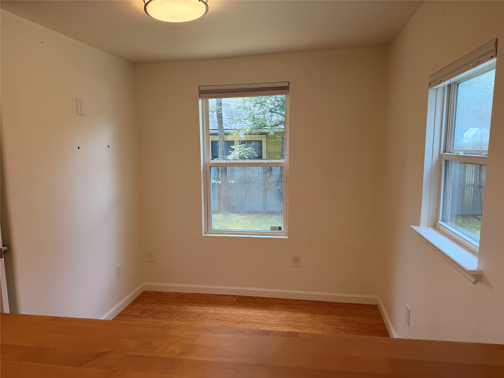 1182 Pandora Street Austin, TX 78702 - Photo 11 of 19 Two windows bathe this room in natural light, showcasing the polished wood flooring.