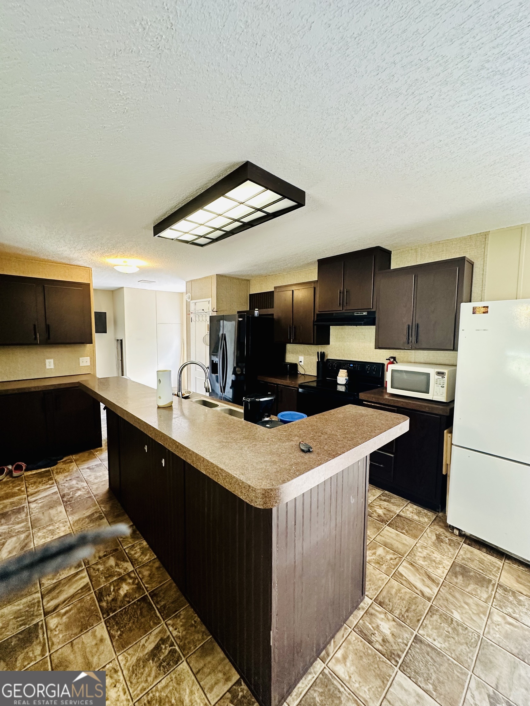 163 Indigo Road Lyons, GA 30436 - Photo 16 of 18 a kitchen with stainless steel appliances kitchen island granite countertop a sink a stove top oven a counter space and cabinets