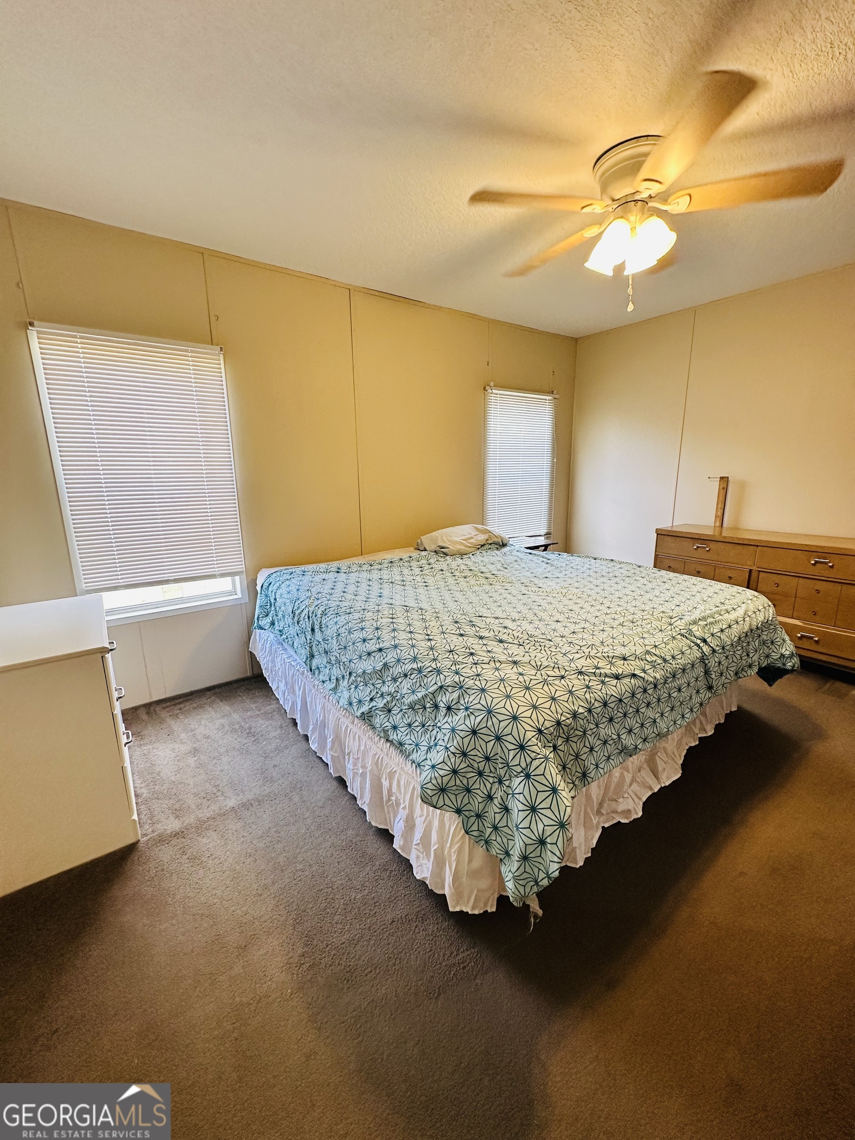 163 Indigo Road Lyons, GA 30436 - Photo 7 of 18 a bed sitting in a room next to a lamp