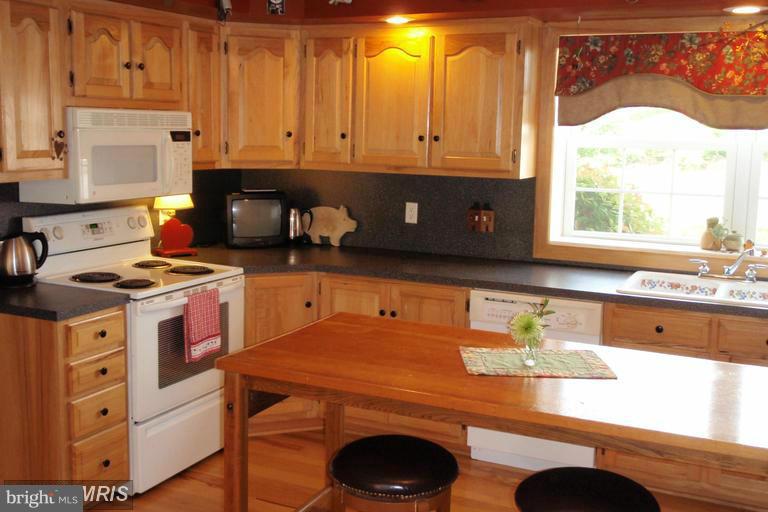 2402 Hoffman Road Greencastle, PA 17225 - Photo 2 of 22 a kitchen with granite countertop a stove a sink and white cabinets
